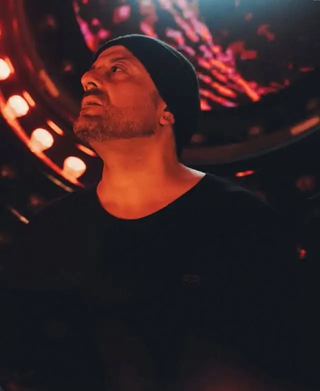 La DJ y productora chilena Valesuchi sentada en su estudio de producción musical en Santiago, rodeada de equipos electrónicos y decoraciones personales.