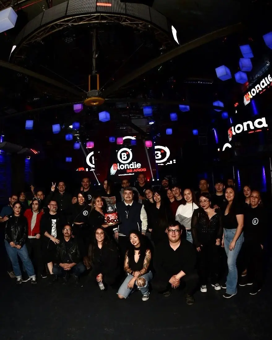 La DJ y productora chilena Valesuchi sentada en su estudio de producción musical en Santiago, rodeada de equipos electrónicos y decoraciones personales.