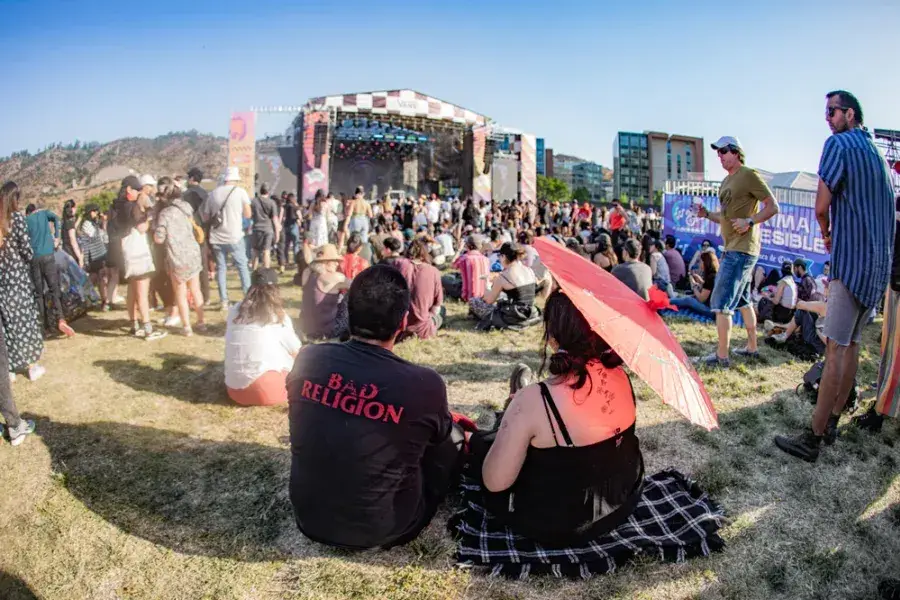 La DJ y productora chilena Valesuchi sentada en su estudio de producción musical en Santiago, rodeada de equipos electrónicos y decoraciones personales.
