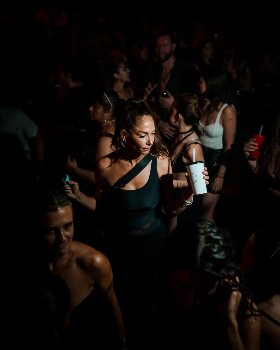 La DJ y productora chilena Valesuchi sentada en su estudio de producción musical en Santiago, rodeada de equipos electrónicos y decoraciones personales.