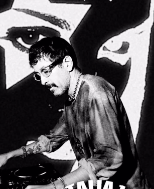 La DJ y productora chilena Valesuchi sentada en su estudio de producción musical en Santiago, rodeada de equipos electrónicos y decoraciones personales.