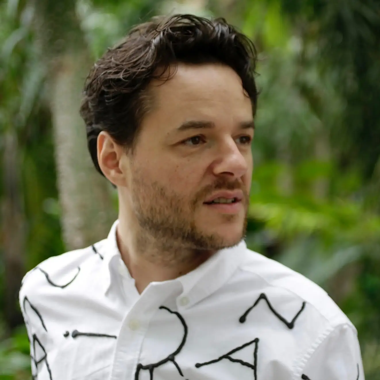 La DJ y productora chilena Valesuchi sentada en su estudio de producción musical en Santiago, rodeada de equipos electrónicos y decoraciones personales.