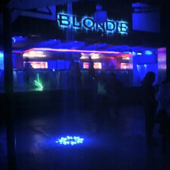 La DJ y productora chilena Valesuchi sentada en su estudio de producción musical en Santiago, rodeada de equipos electrónicos y decoraciones personales.