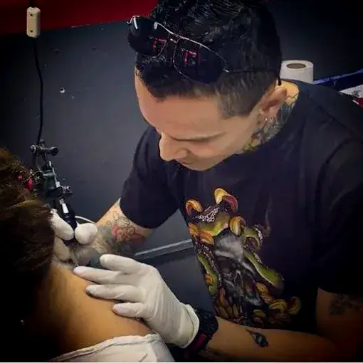 La DJ y productora chilena Valesuchi sentada en su estudio de producción musical en Santiago, rodeada de equipos electrónicos y decoraciones personales.