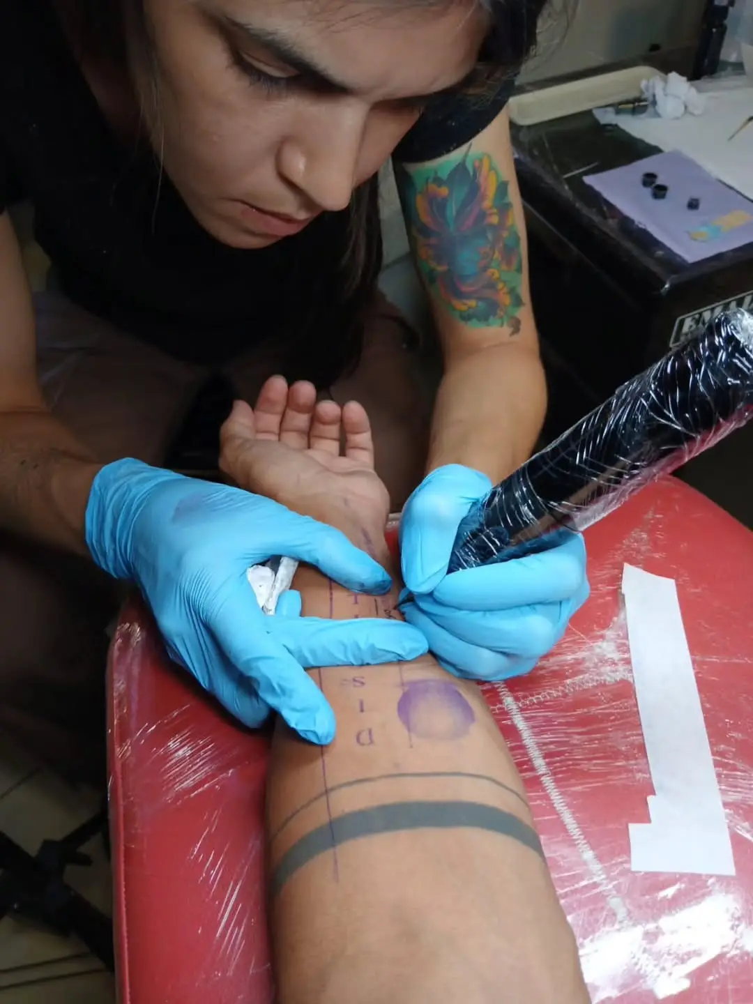 La DJ y productora chilena Valesuchi sentada en su estudio de producción musical en Santiago, rodeada de equipos electrónicos y decoraciones personales.