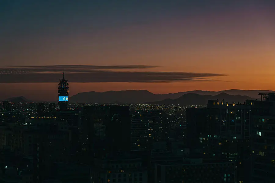 Vista nocturna de Santiago de Chile con el skyline iluminado y la cordillera de fondo
