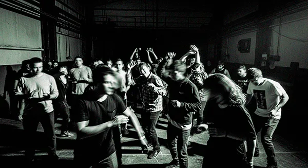 El Cuerpo como Lienzo: Baile, Tatuajes y Techno 64 Personas bailando en una fiesta techno underground en Santiago de Chile, ambiente oscuro con movimiento y energía colectiva.